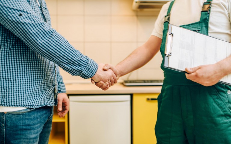 Repairman and customer shake hands handyman